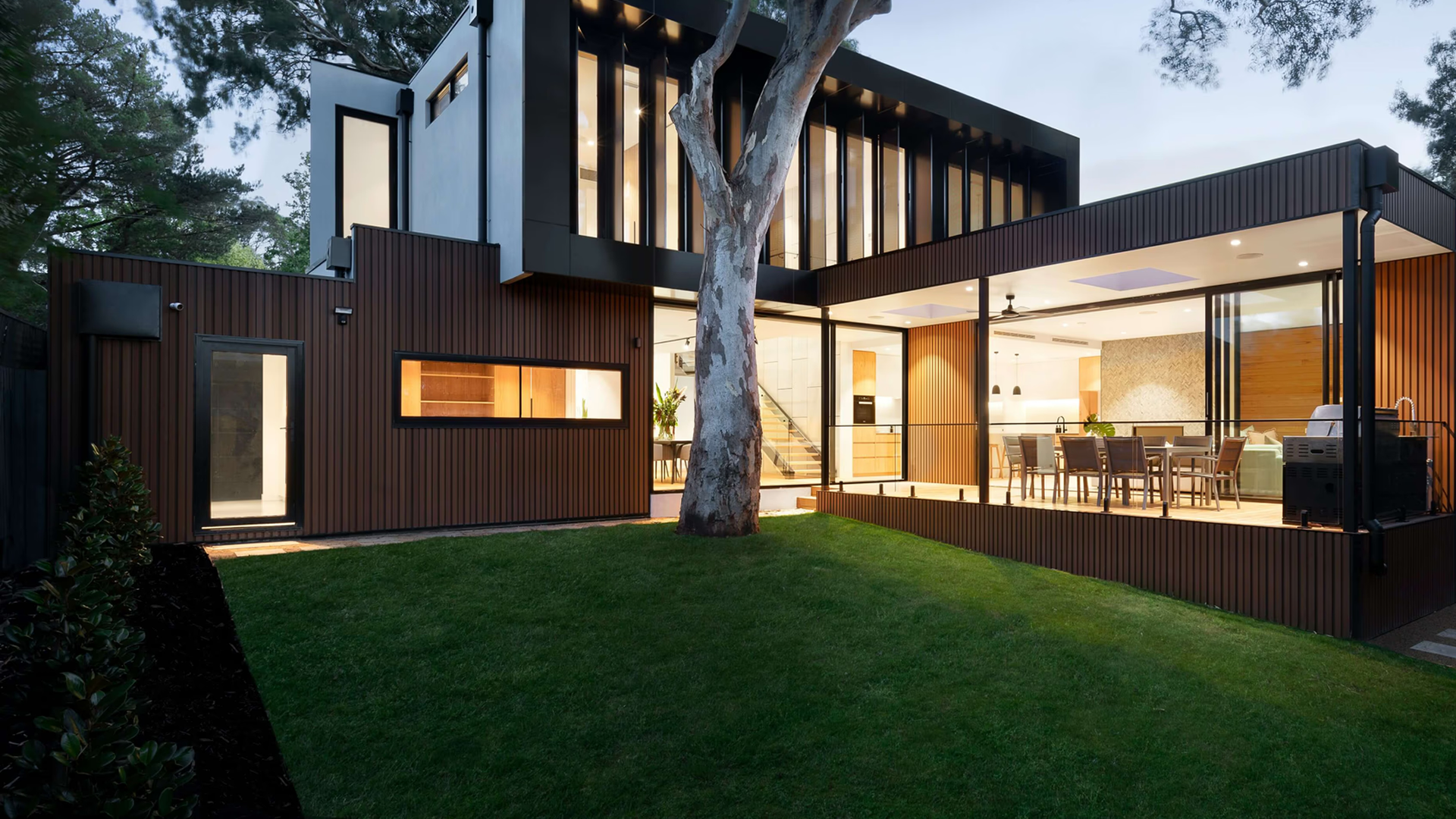 Modern luxury residence with glass walls and landscaped outdoor living space